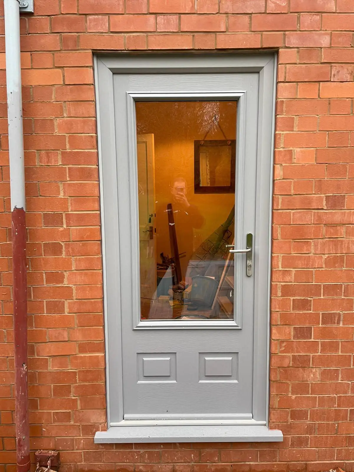 Grey entrance door with a tall glazed panel